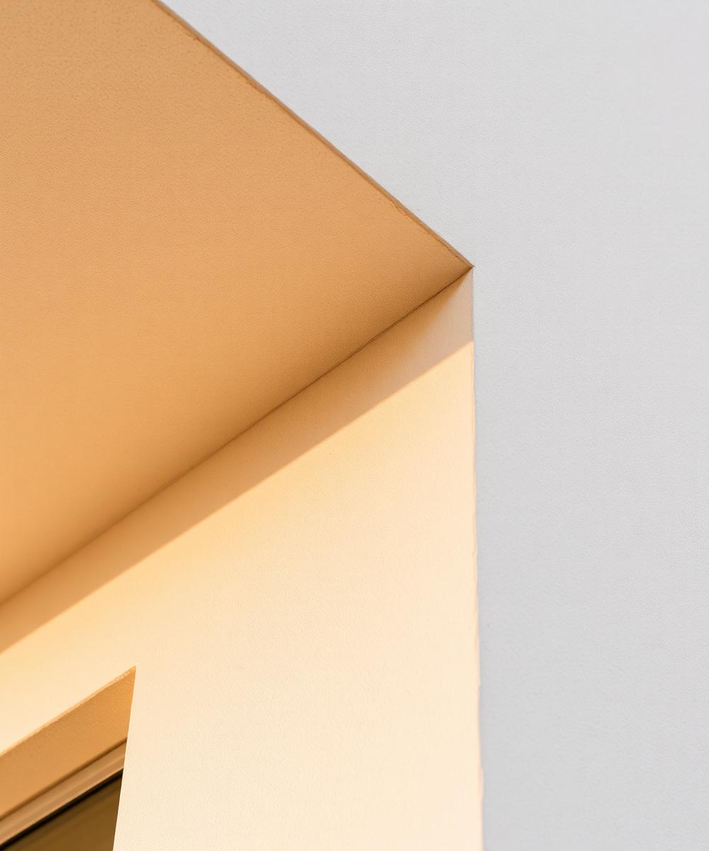 Smooth troweled stucco wall corner on a modern building in raking light